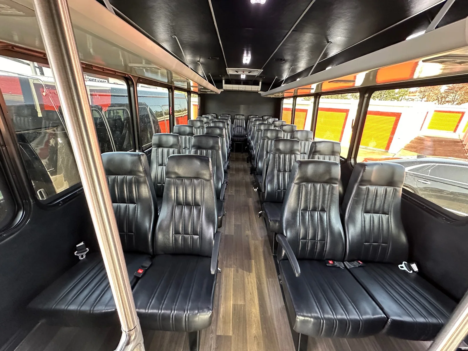 Executive shuttle interior with rows of black leather seats