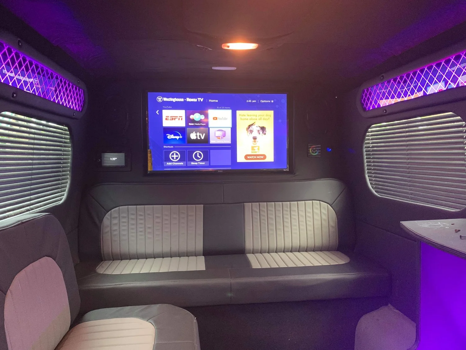 Luxury Raleigh Sprinter limo interior with colorful lighting and lounge seating
